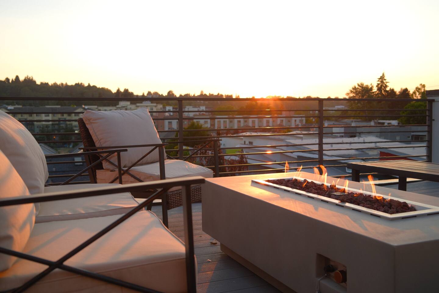 Gas fire table burning on the private rooftop deck at sunset